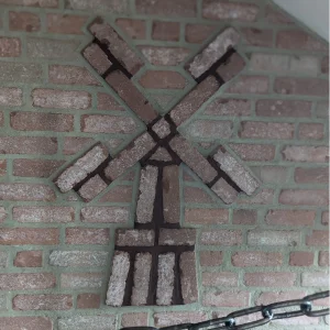 Mit Klinkerriemchen verblendetes Mauerwerk samt stilisierter Mühle.